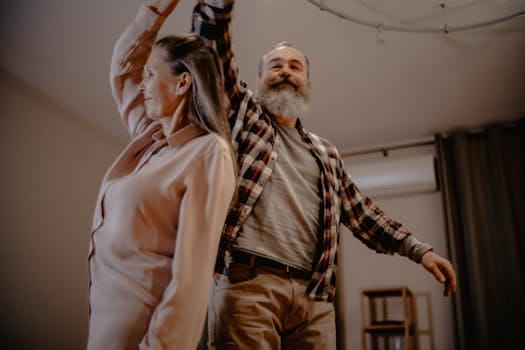Make the Most of Life: Embrace Every Moment with Joy 3 An elderly couple enjoying a dance together in their cozy living room, showcasing love and companionship.