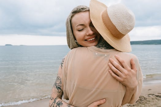 Living with Values That Outlast You: What Will People Remember You For? 5 Two women embracing on a serene beach, expressing joy and friendship.