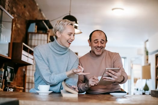 Living with Values That Outlast You: What Will People Remember You For? 6 Cheerful adult diverse couple in casual clothes watching funny video on tablet and laughing while drinking coffee at table in apartment