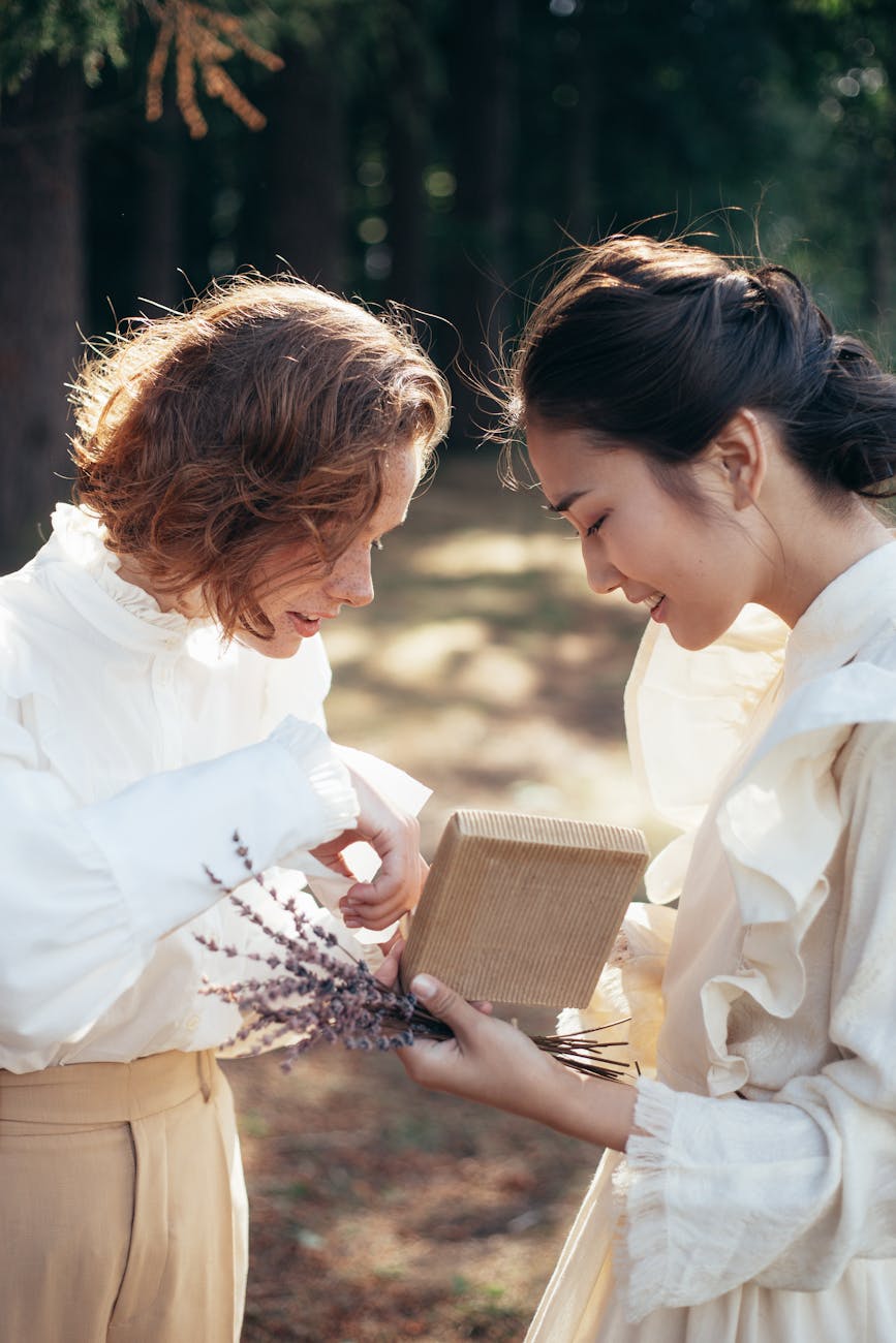 The Power of Appreciation: A Key to Better Relationships and Success 3 smiling women in old fashioned clothing looking at gift in park
