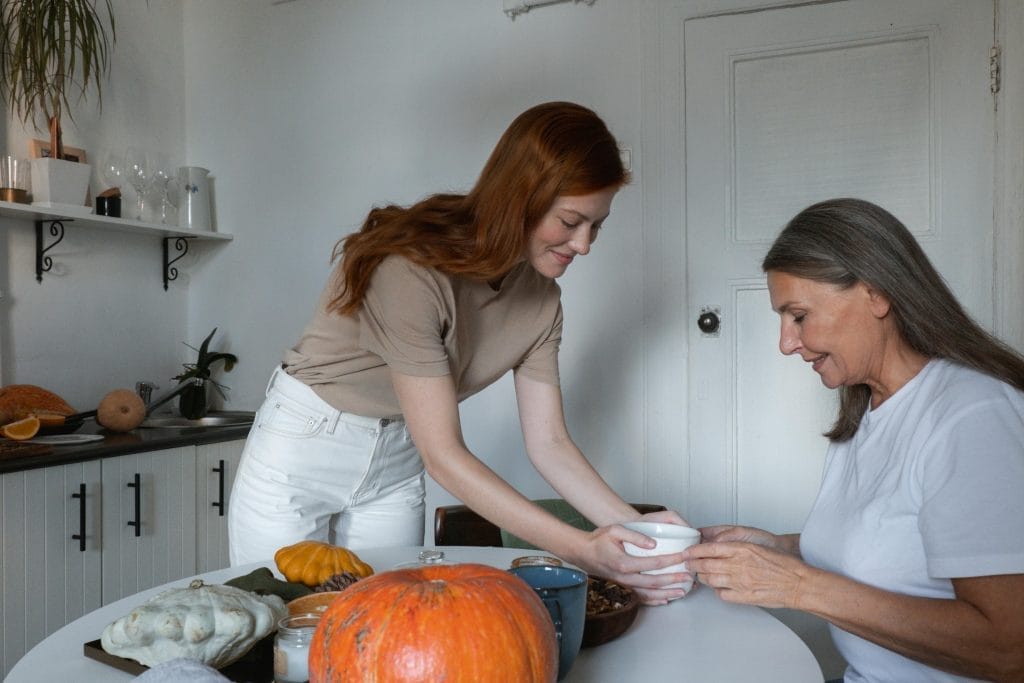 How to Find True Joy in Life: Simple Ways to Create Lasting Happiness 4 A young woman and her mother enjoy a meal together at their cozy kitchen table.