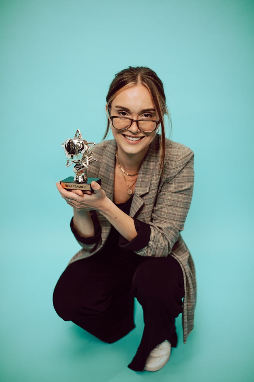The Power of Appreciation: A Key to Better Relationships and Success 4 a woman in formal attire holding a trophy while smiling at the camera