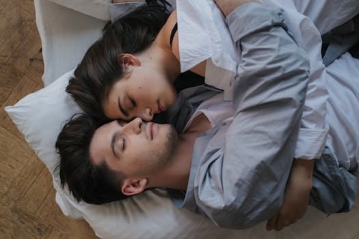 Intimate moment of a couple embracing while resting indoors, showcasing love and togetherness.
