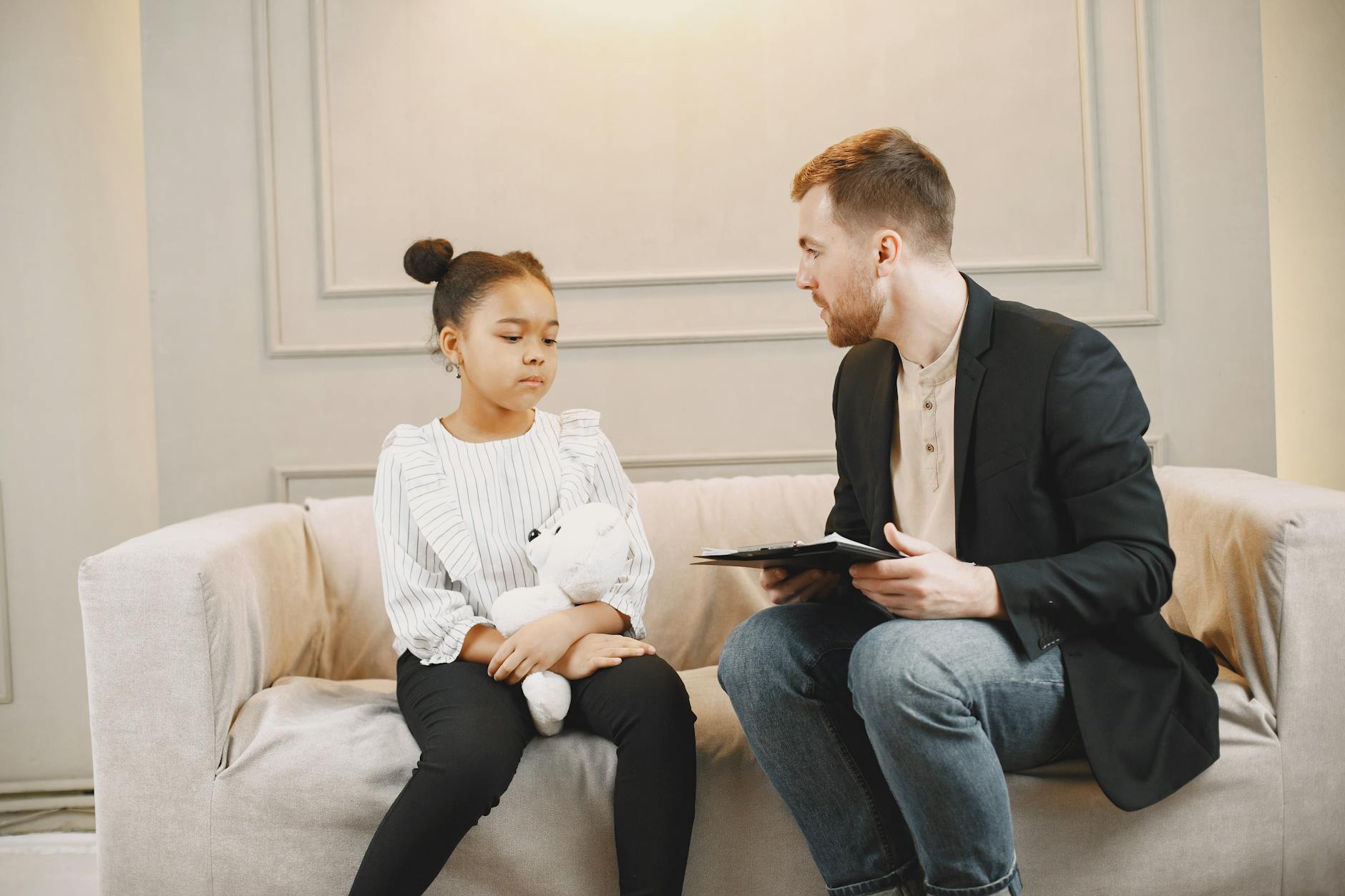 man in black blazer talking to a child