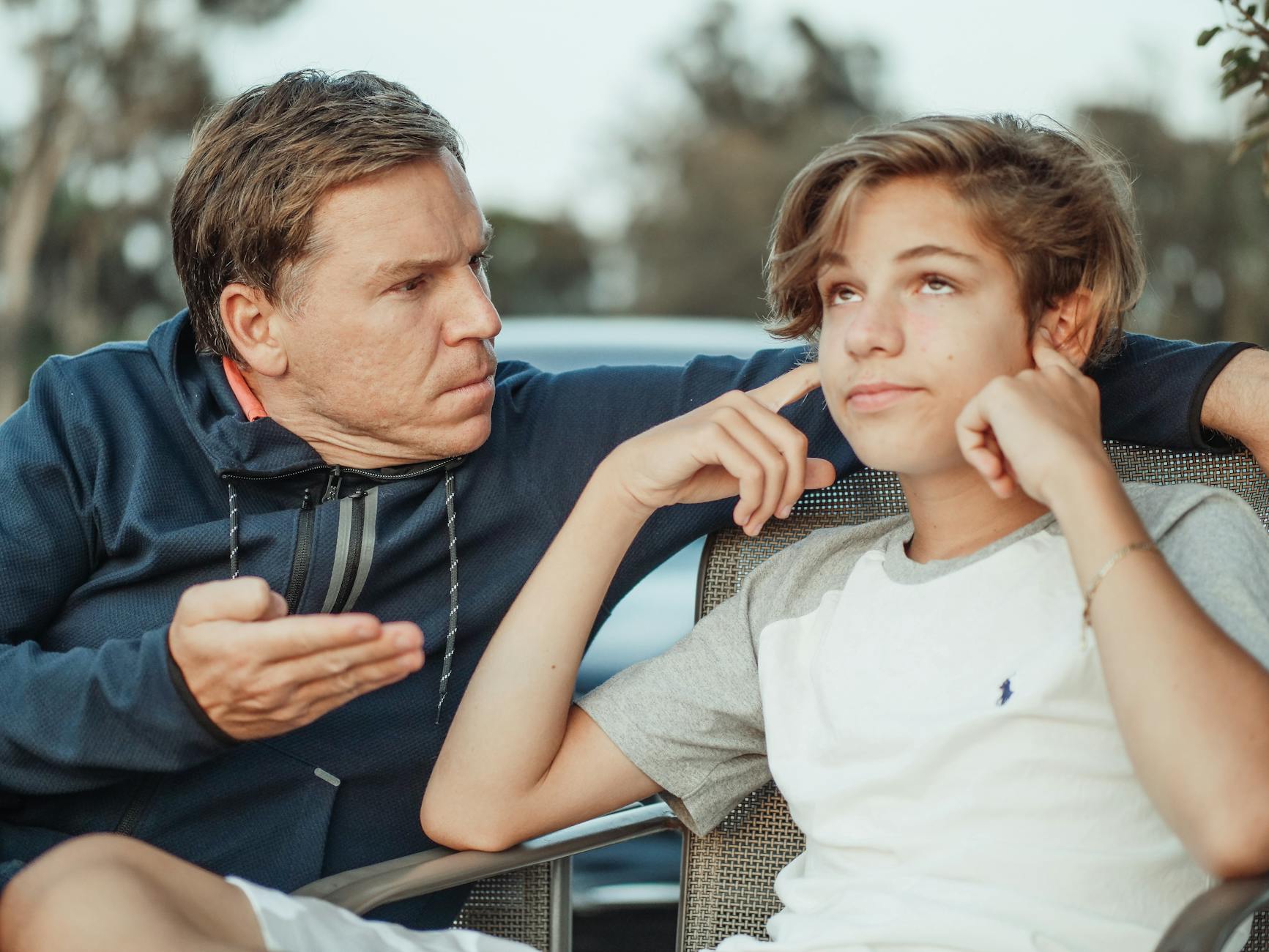 man scolding his son