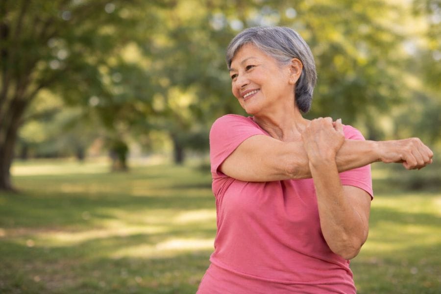 Stretching Exercises for Seniors 5 Senior woman doing shoulder stretch exercise to improve shoulder flexibility